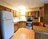 Kitchen with stainless steel appliances, light hardwood / wood-style floors, and decorative backsplash