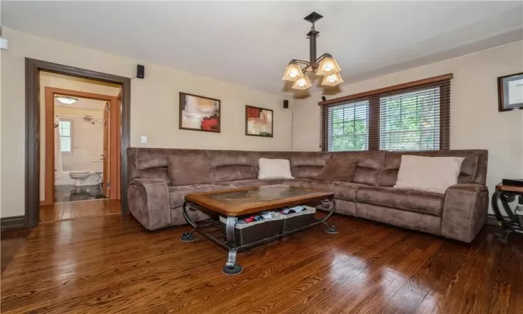 Living room with dark hardwood / wood-style floors and a chandelier