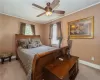 Carpeted bedroom featuring ornamental molding and ceiling fan