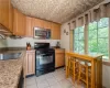 Kitchen featuring black gas range, sink, and light tile floors