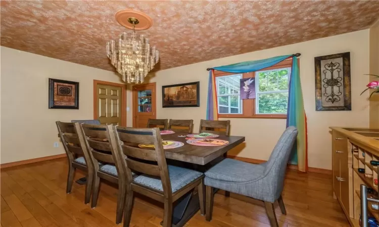 Dining room with a notable chandelier and wood-type flooring