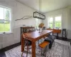 Dining room with a wealth of natural light, wood walls, and hardwood floors