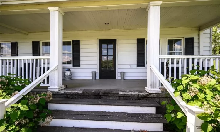 View of exterior entry featuring covered porch