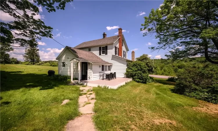 Rear view of property featuring a yard and a patio area