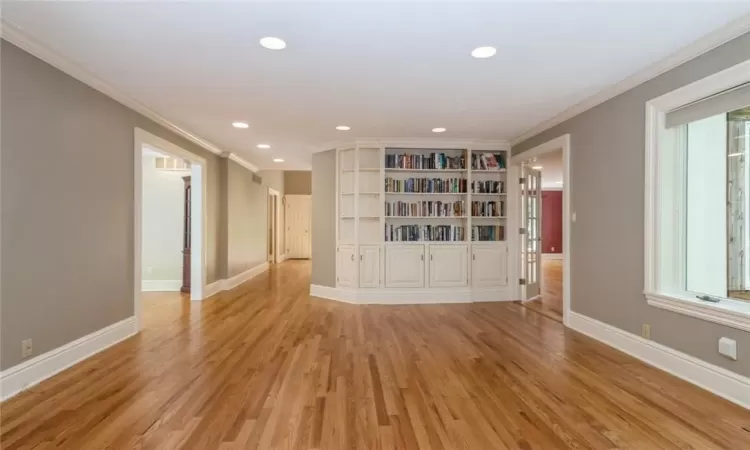 Unfurnished living room featuring light hardwood / wood-style flooring and crown molding