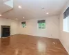 Unfurnished living room featuring a wood stove and wood-type flooring