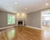 Unfurnished living room featuring ceiling fan, light hardwood / wood-style flooring, a fireplace, and crown molding