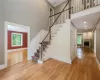 Stairway featuring a high ceiling, ornamental molding, and light hardwood / wood-style flooring