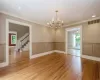 Empty room featuring a healthy amount of sunlight, ornamental molding, light hardwood / wood-style floors, and ceiling fan with notable chandelier