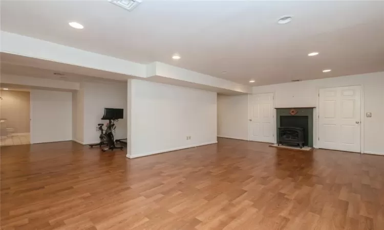 Unfurnished living room with hardwood / wood-style flooring and a wood stove