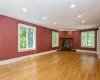 Unfurnished living room featuring a healthy amount of sunlight, light wood-type flooring, and crown molding