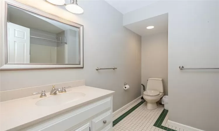 Bathroom with toilet, tile floors, and large vanity, shower/tub