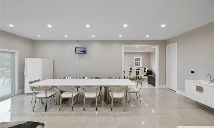 Dining area with sink and light tile floors