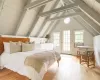 Bedroom featuring vaulted ceiling with beams, light wood-type flooring, and access to outside