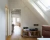 Additional living space with wood-type flooring and vaulted ceiling with skylight