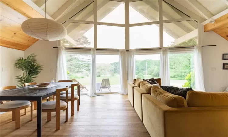 Living room with high vaulted ceiling, beamed ceiling, hardwood / wood-style flooring, and wood ceiling