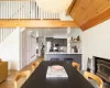 Dining room with lofted ceiling with beams and light hardwood / wood-style flooring