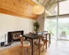 Dining room with beamed ceiling, high vaulted ceiling, a fireplace, and light wood-type flooring