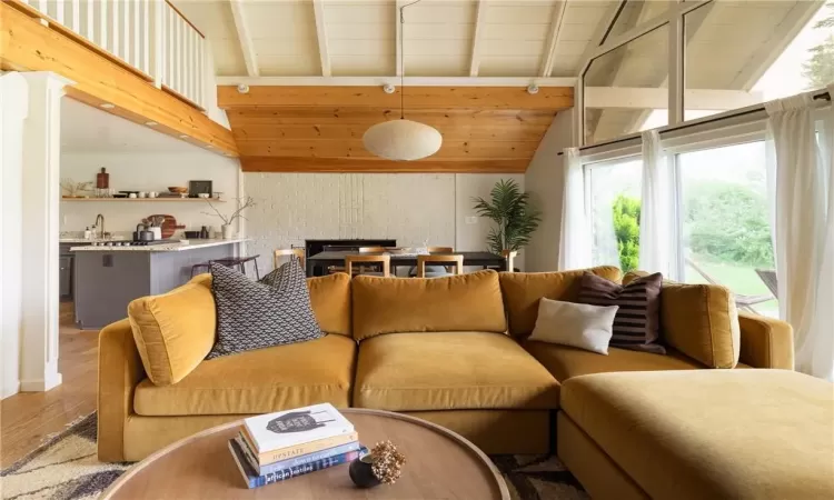 Living room featuring sink, hardwood / wood-style flooring, and lofted ceiling with beams