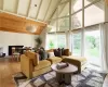 Living room with beamed ceiling, high vaulted ceiling, a fireplace, and wood-type flooring