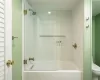 Bathroom with tiled shower / bath combo and toilet