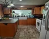 Kitchen featuring decorative light fixtures, stove, tasteful backsplash, refrigerator, and sink