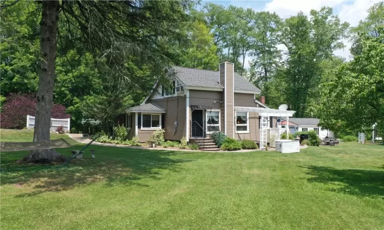 View of front of home with a pergola and a front yard