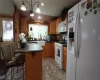 Kitchen with hanging light fixtures, white appliances, sink, tasteful backsplash, and light tile floors