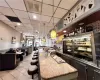 Bar featuring hanging light fixtures, a paneled ceiling, and light tile floors