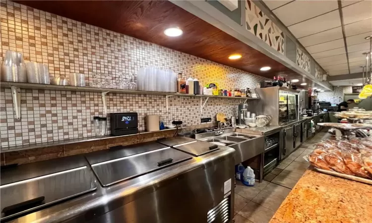 Kitchen with tasteful backsplash and tile floors