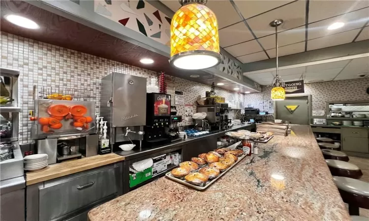 Kitchen with wine cooler, a paneled ceiling, and a kitchen bar