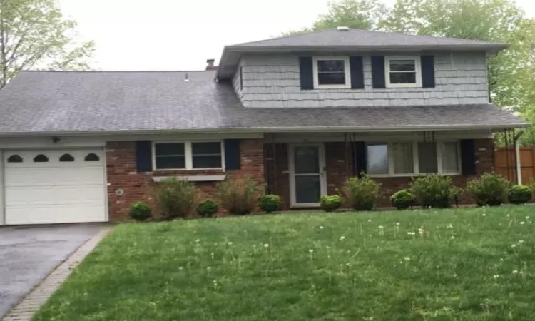 View of front of home with a garage and a front yard