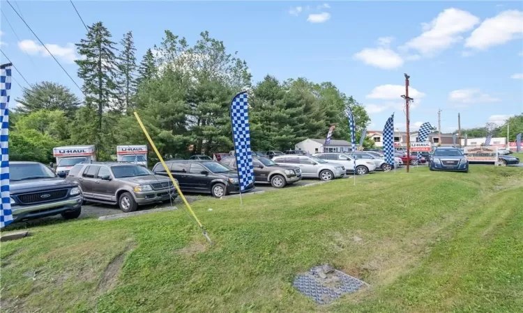 View of parking featuring a yard