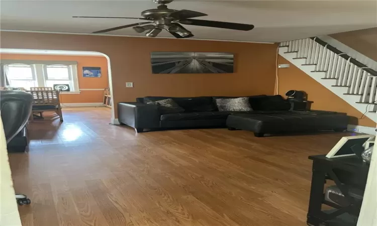 Living room with ceiling fan and hardwood / wood-style floors