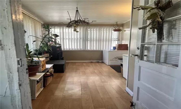 Mudroom/Entry porch w/ tons of light, wood-type flooring, and an inviting chandelier