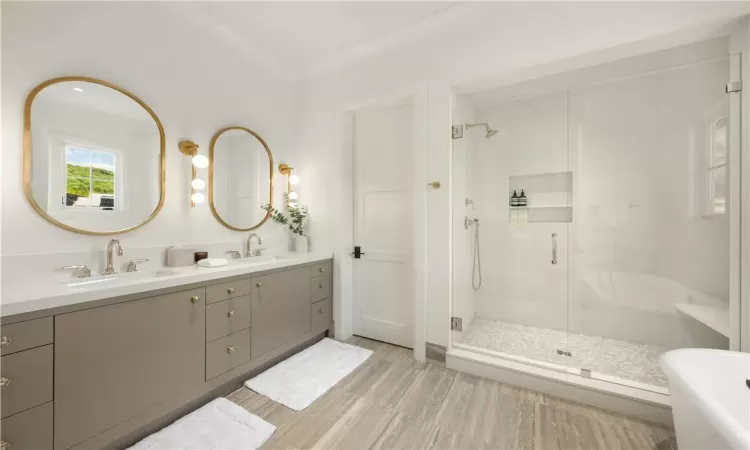 Bathroom featuring independent shower and bath, dual vanity, and ornamental molding