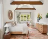 Bedroom with hardwood / wood-style flooring and vaulted ceiling with beams