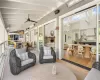 Sunroom featuring ceiling fan and beam ceiling