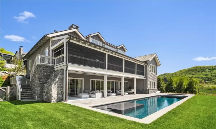 Rear view of house featuring a yard, a sunroom, an outdoor living space, and a patio area