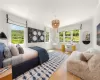 Bedroom with hardwood / wood-style floors, ornamental molding, and multiple windows