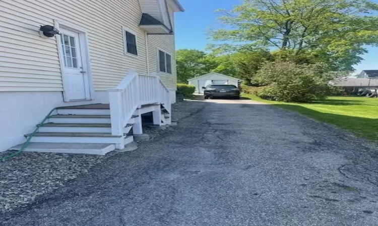 View of property exterior featuring a garage and an outdoor structure