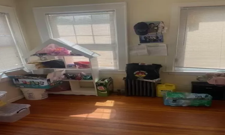 Playroom featuring hardwood / wood-style floors and radiator heating unit