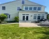 Rear view of house with a patio area and a lawn