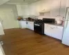 Kitchen with dark hardwood / wood-style floors, fume extractor, and stove