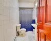 Bathroom featuring tile walls, tile flooring, and toilet