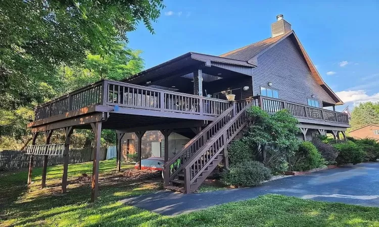 Back of property featuring a deck and a yard