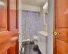 Bathroom with tile flooring, a baseboard radiator, toilet, and large vanity