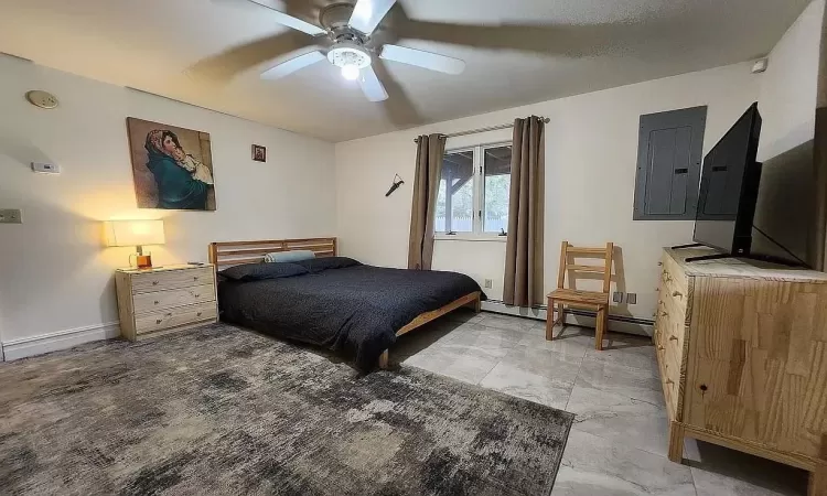 Tiled bedroom with a baseboard heating unit and ceiling fan