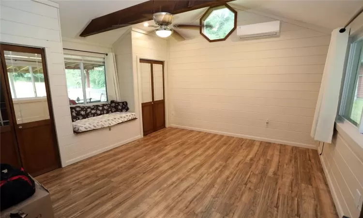 Unfurnished bedroom featuring a mini-split unit and wood-style flooring