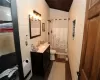 Bathroom with wooden walls, hardwood / wood-style flooring, toilet, and vanity